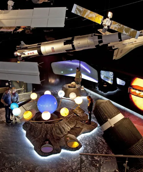 Ausstellungsraum mit Planetenmodell und Raumschiff-Skulptur.