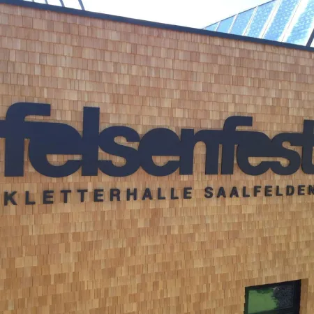 Schild mit dem Text 'felsenfest KLETTERHALLE SAALFELDEN'