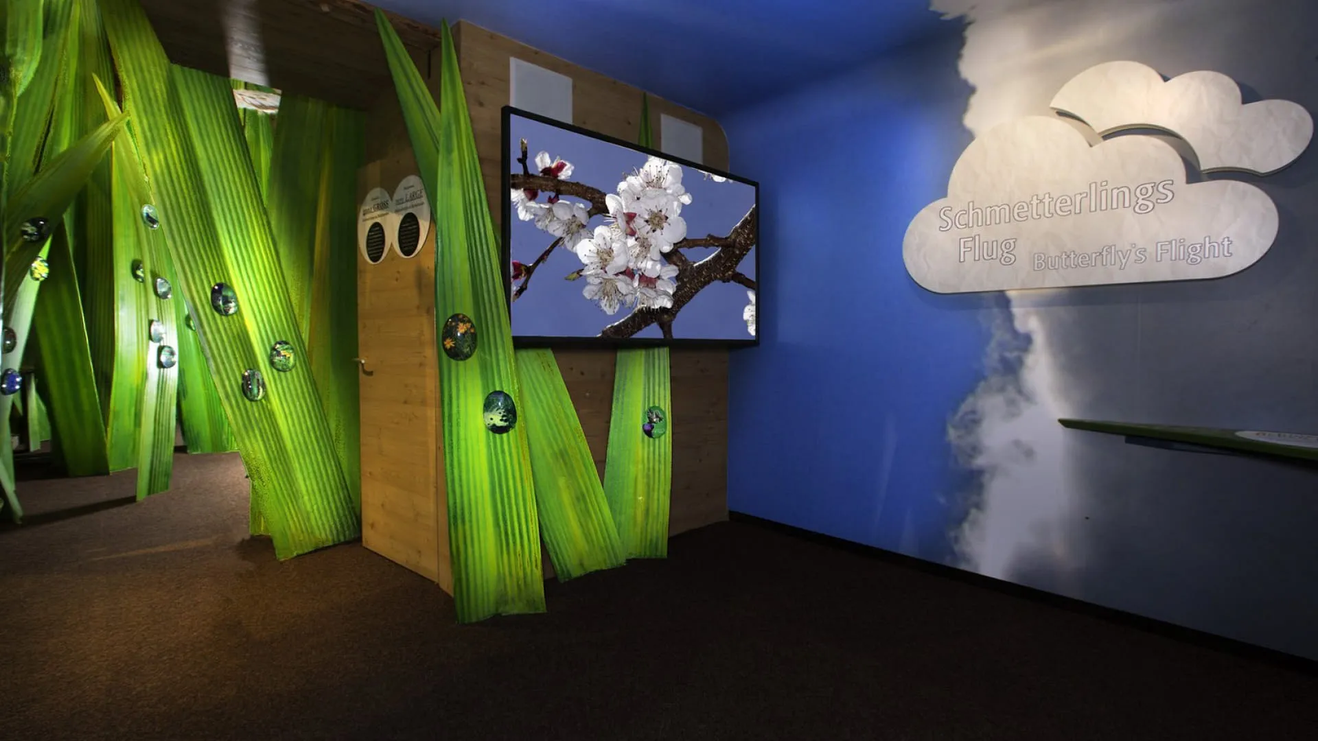 Interieur mit grünen Elementen und Bildschirm mit Blüten
