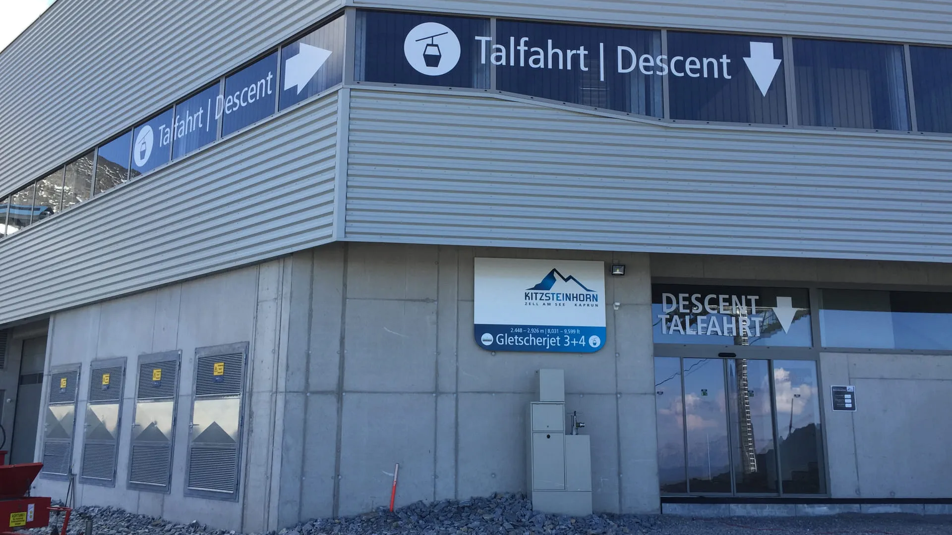 Gebäudeeingang mit Schildern für Talfahrt und Descent