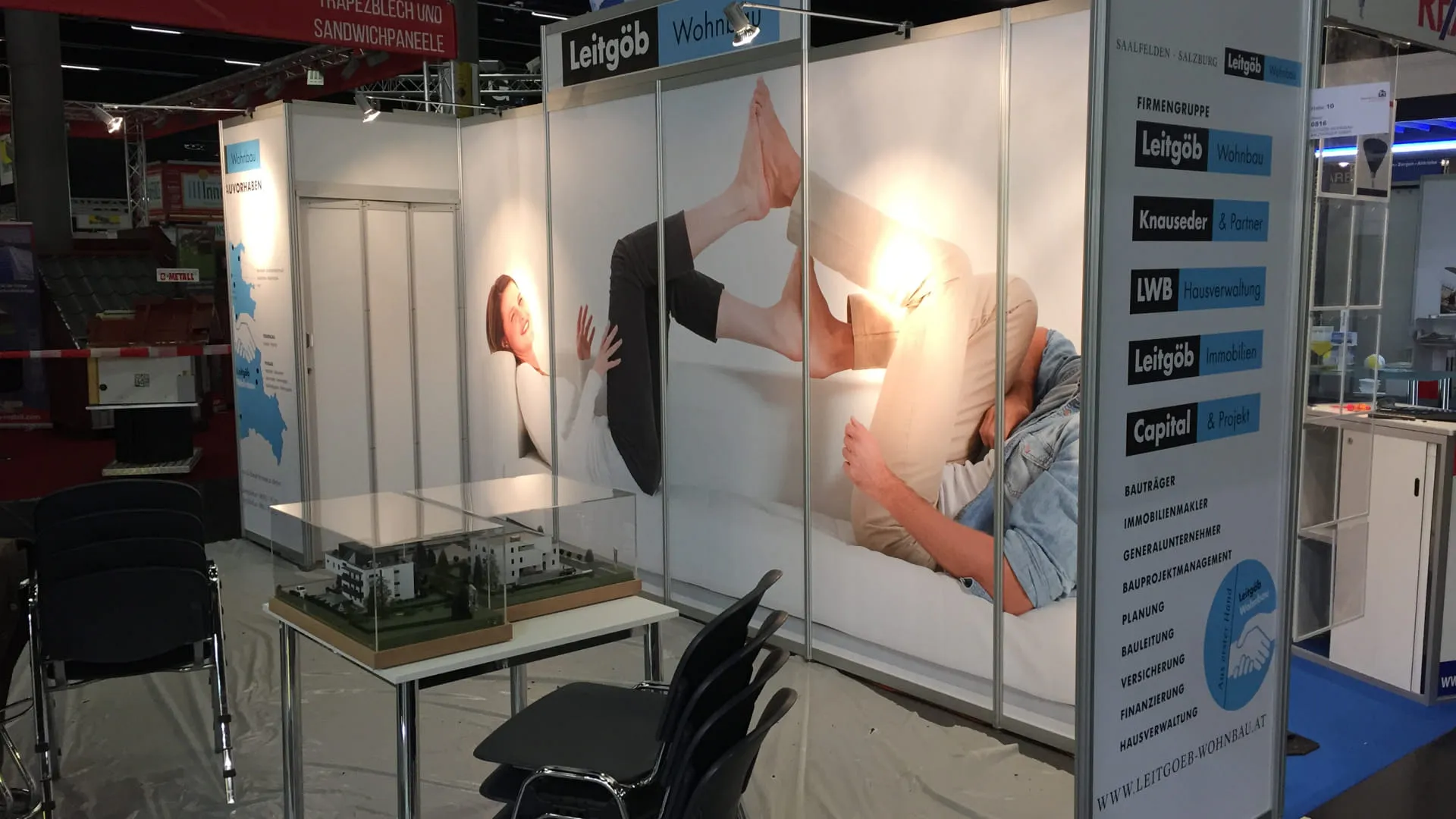 Messestand mit Grafiken und einem Modell auf dem Tisch