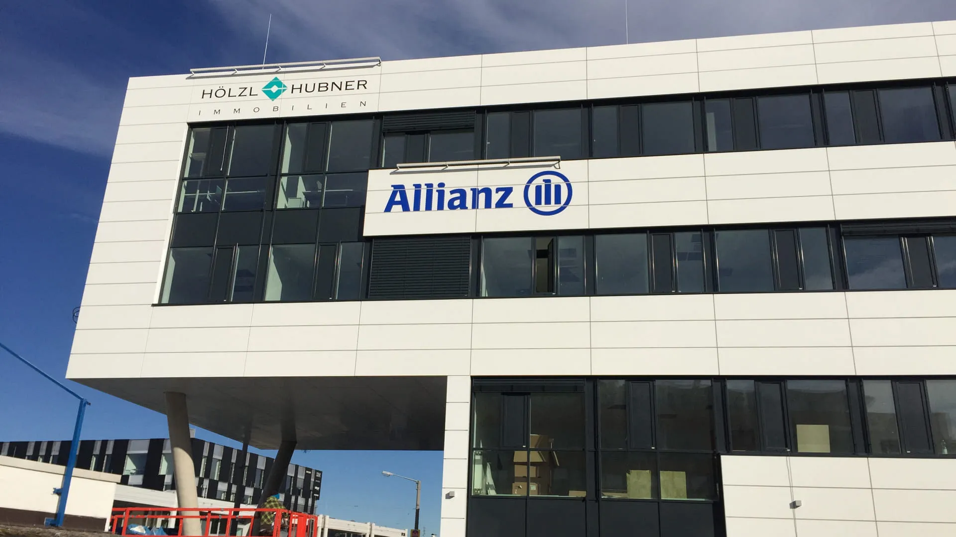 Gebäude mit Allianz-Logo und Hölzi Hubner-Schild
