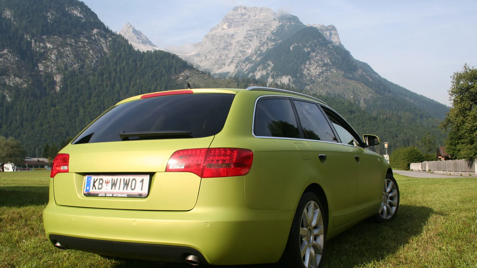 Limousine in Neonfarbe vor Berglandschaft