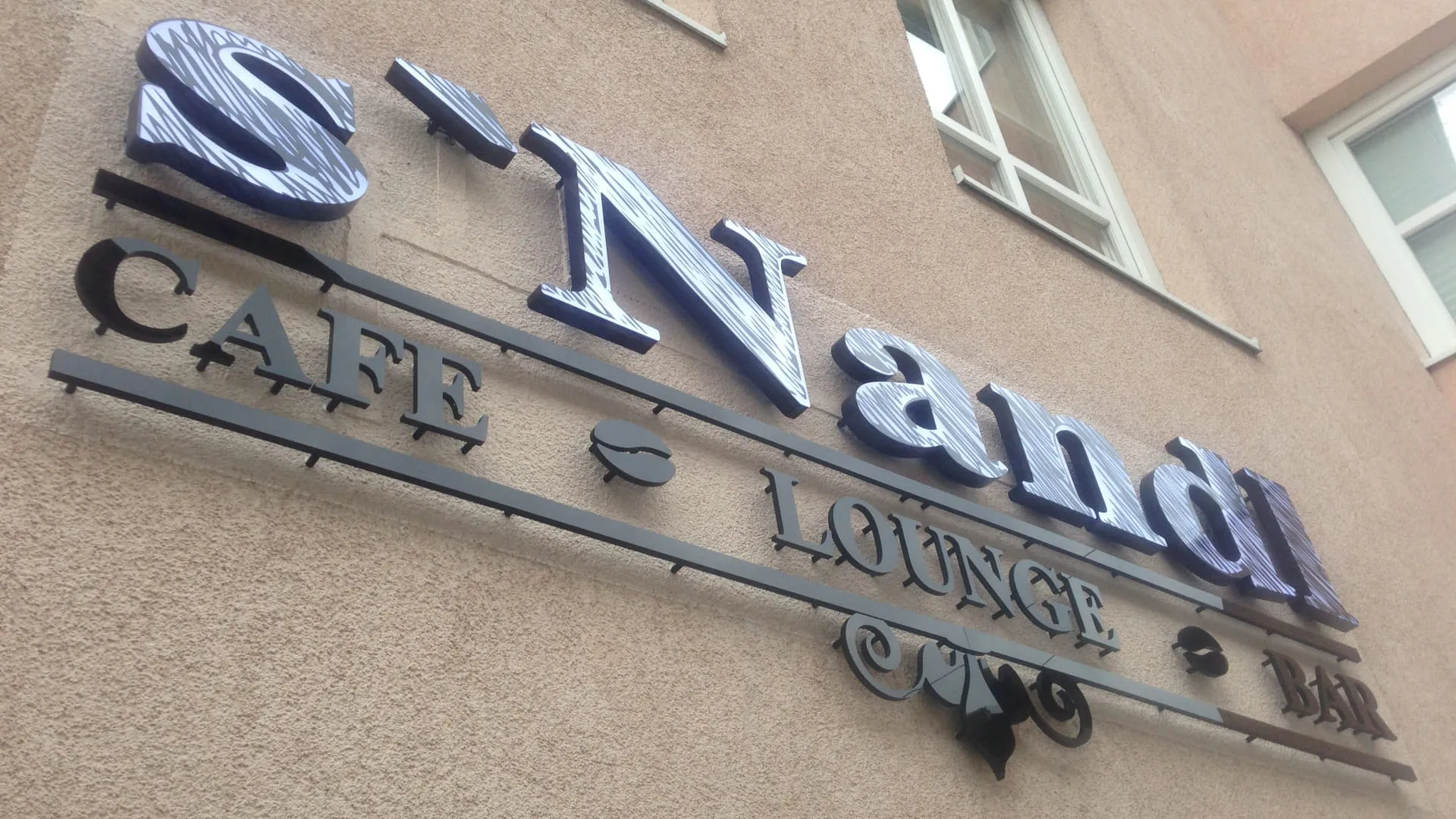 Schild von s'Nandi Café Lounge Bar an einer Wand
