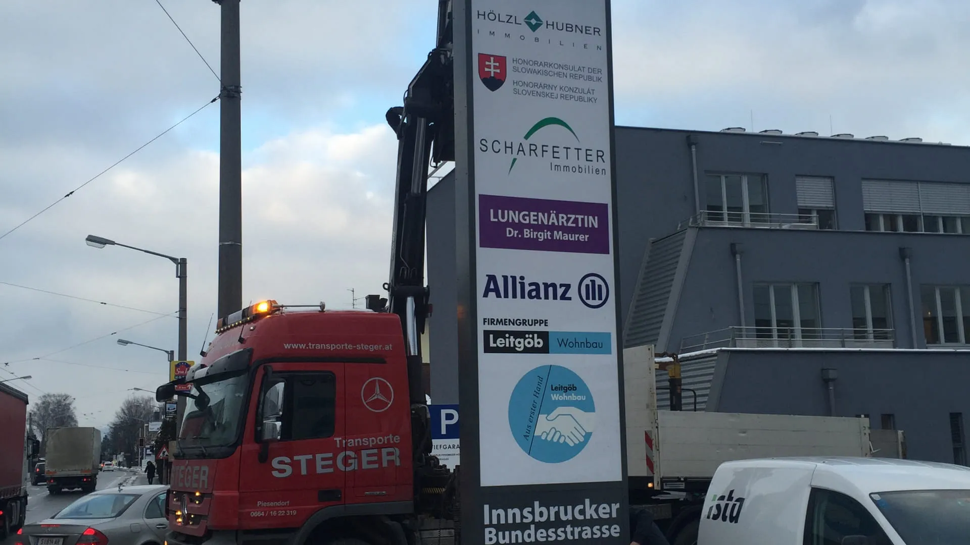 Rote Lkw hebt Werbeschild an der Innsbrucker Bundesstraße 85