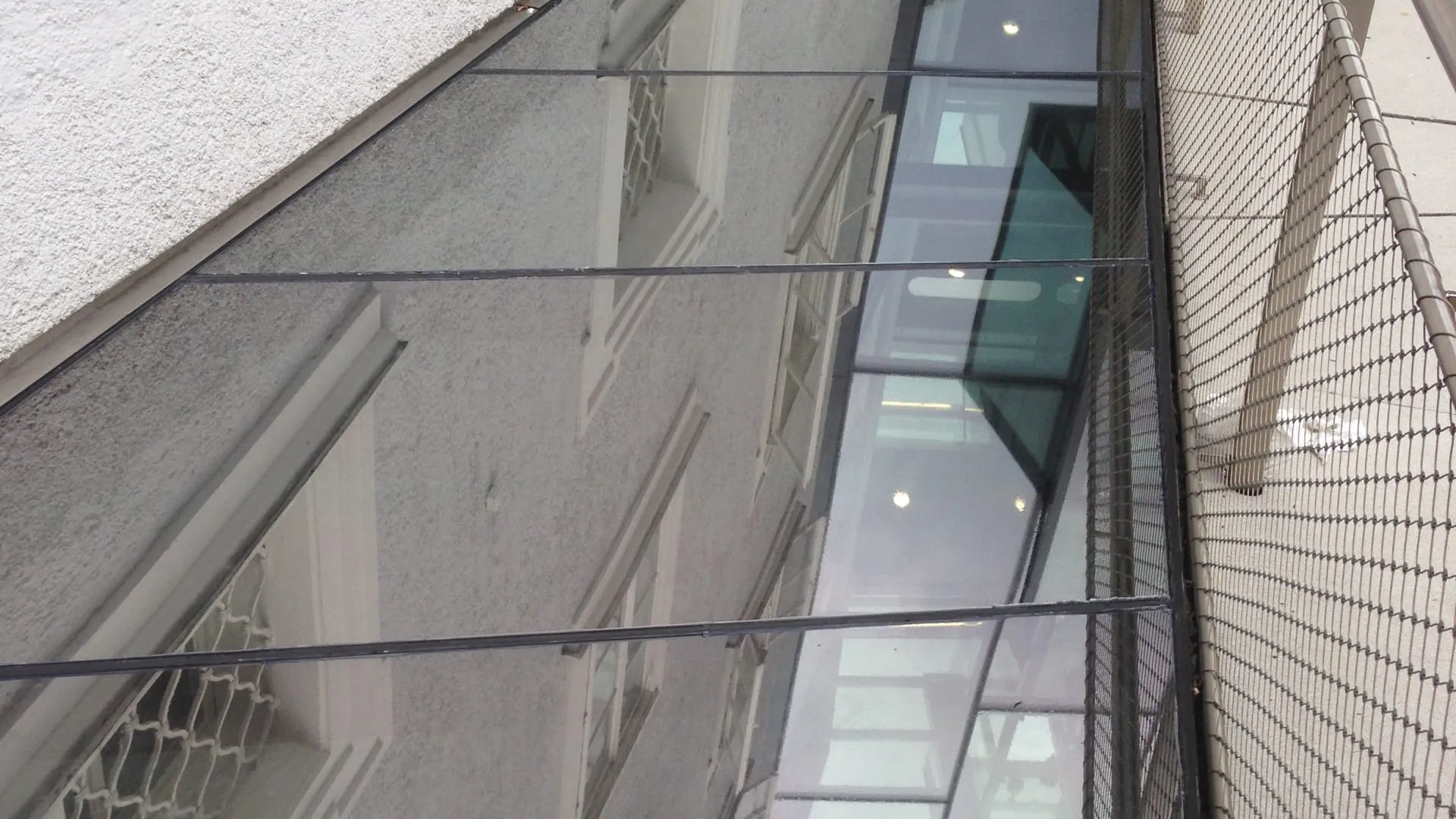 Glaserne Überdachung entlang einer Wand, reflektierende Oberfläche