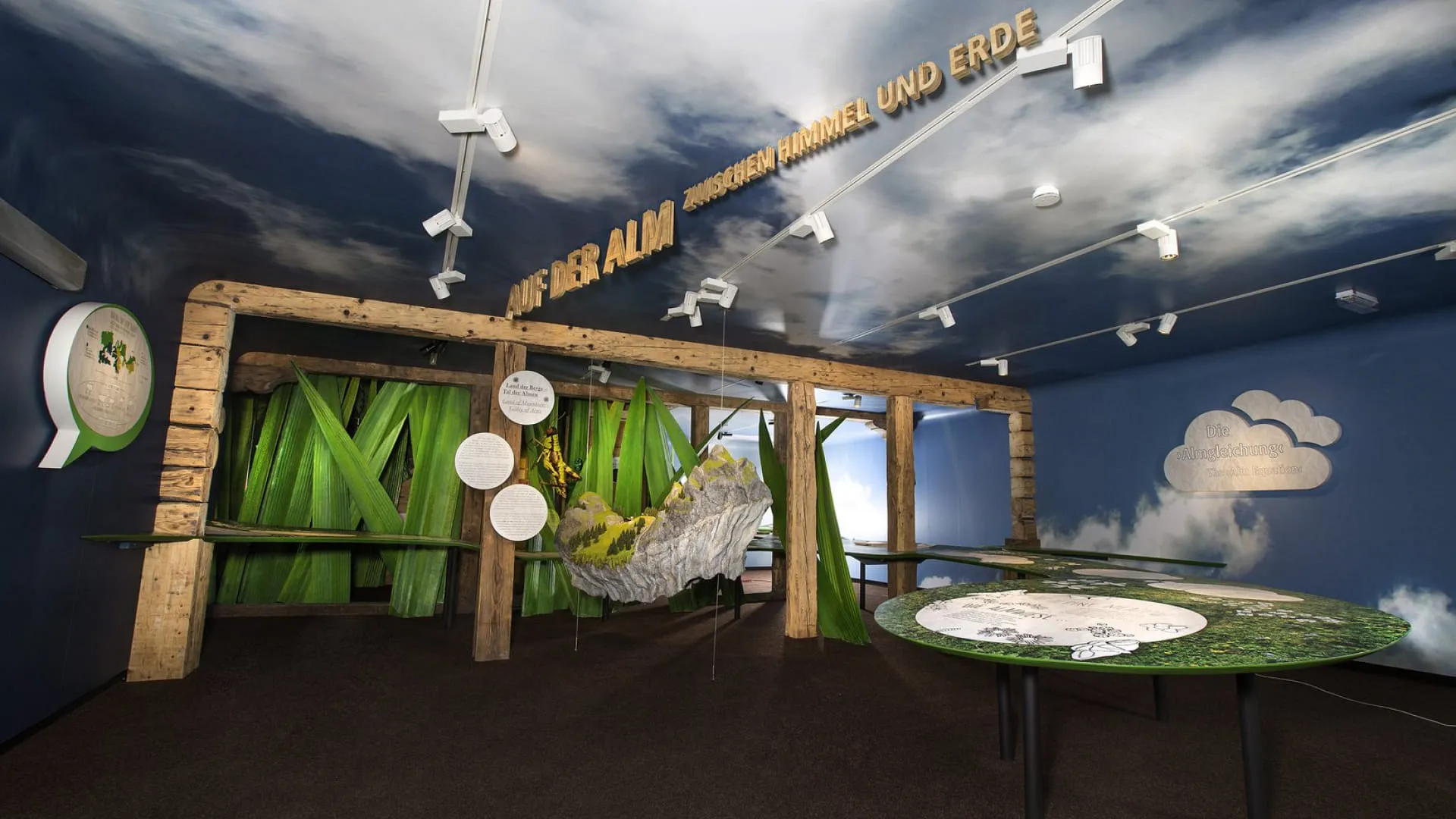 Ausstellung mit Holzstrukturen und Berglandschaften