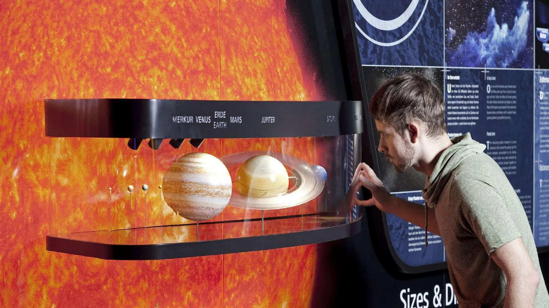 Mann betrachtet Modell des Sonnensystems mit Planeten
